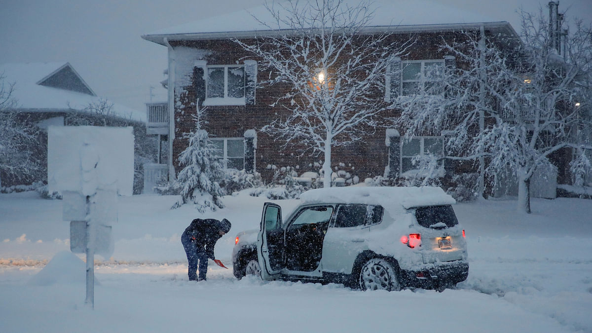 A woman shovels snow around her stuck car during a snowstorm in Arlington Heights, Illinois, US on 26 November 2018. Photo: Reuters