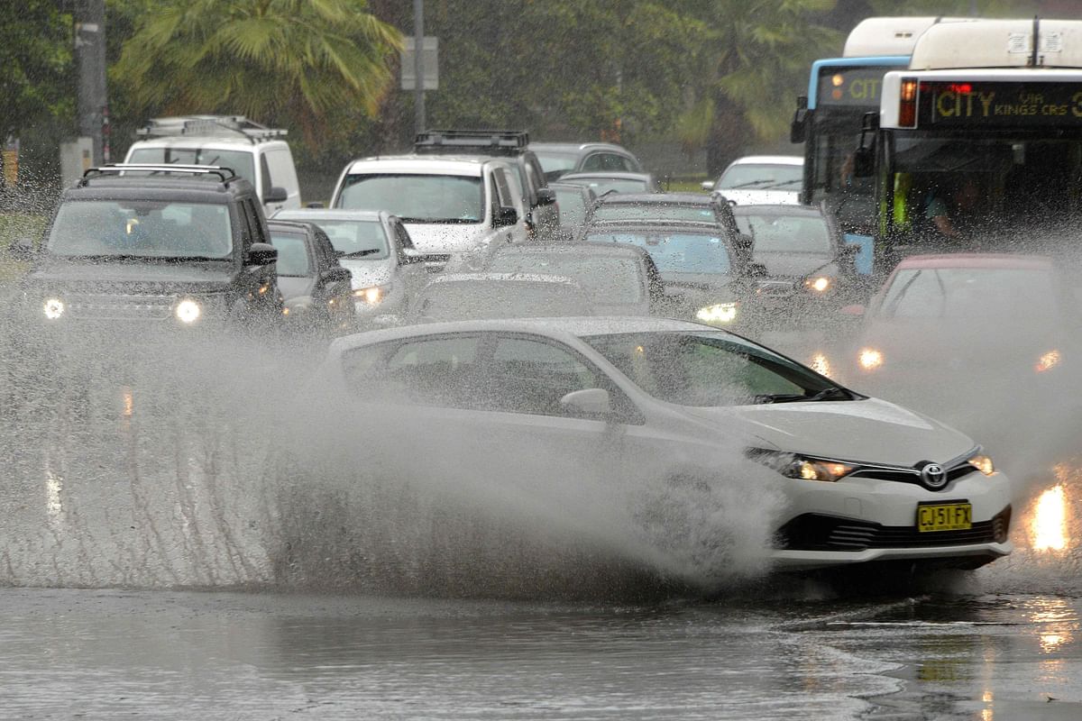 A car drives through water, caused by heavy rain, on a road in Sydney on 28 November 2018. Photo: AFP
