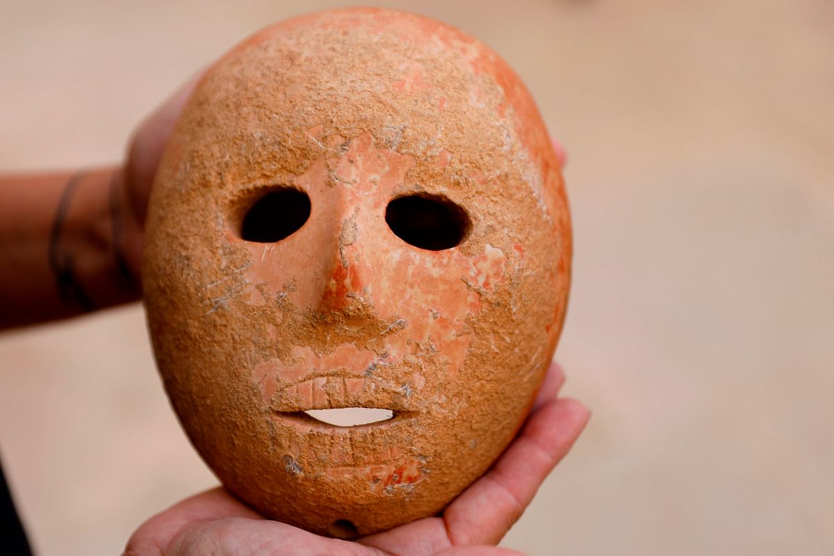 Israeli archeologist Ronit Lupu of the IAA Antiquities Theft Prevention Unit holds a rare stone mask dating to the Neolithic (new stone age) period which was found at the Pnei Hever region of southern Hebron mount, on 28 November 2018. Photo: AFP