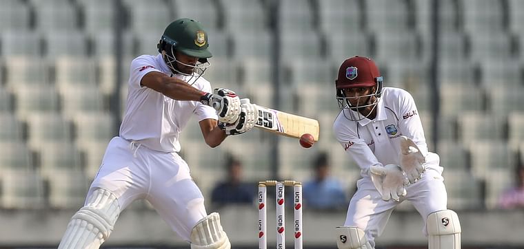 Bangladesh's Shadman Islam (L) plays a shot as West Indies wicketkeeper Shane Dowrich watches during the first day of the second Test cricket match between Bangladesh and West Indies in Dhaka on 30 November 2018