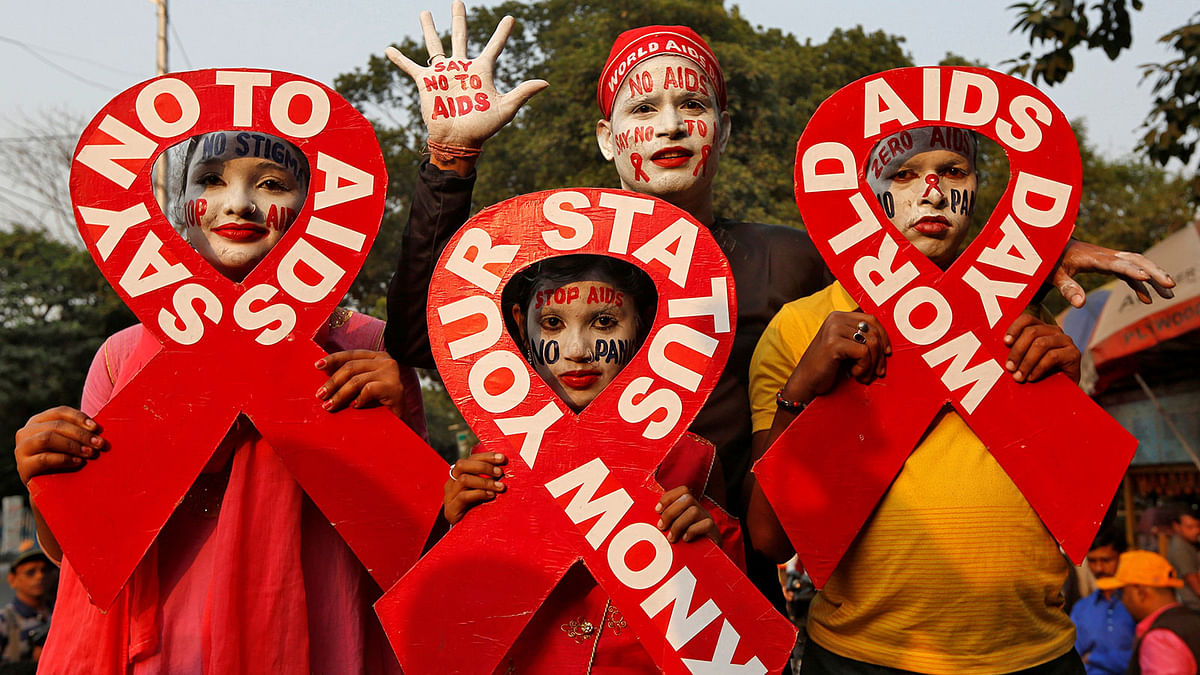 People with painted faces hold ribbon cut-outs as they pose during an HIV/AIDS awareness campaign on the eve of World AIDS Day in Kolkata, India, 30 November 2018. Photo: Reuters