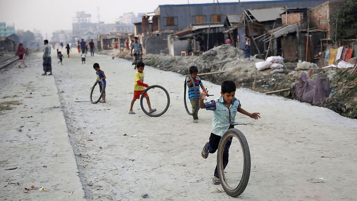Children play with tyres along a street in Dhaka, Bangladesh on 28 November 2018. Photo: Reuters