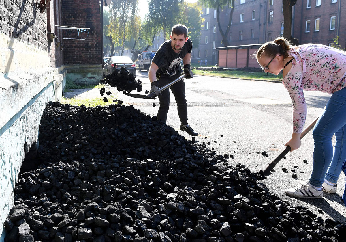 A coal miner with his wife throw coal into a basement of a house in Mikolow on October 12, 2018 in Poland`s southern mining region of Silesia. In Brussels, Berlin and Paris, coal is the enemy. It produces the carbon dioxide blamed for the planet`s rising temperatures. Despite COP24 climate talks, Polish miners see future in coal. Photo: AFP