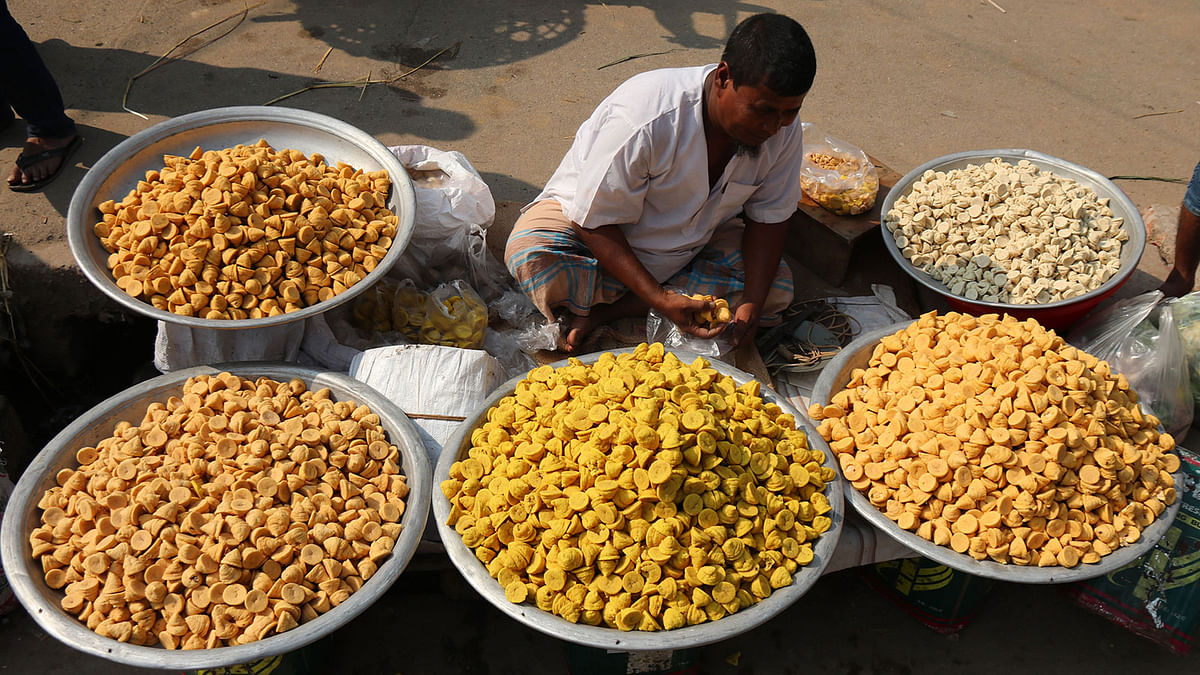 A man selling lentil balls at Sharatnagar, Bhangura, Pabna on 1 December. These sell at Tk 100 to 150. Photo: Hasan Mahmud