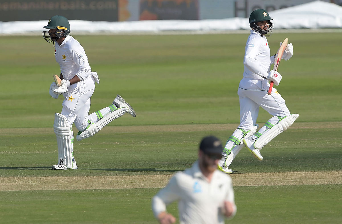 Pakistani batsmen Azhar Ali (R) and Haris Sohail run between the wickets during the second day of the third and final Test cricket match between Pakistan and New Zealand at the Sheikh Zayed International Cricket Stadium in Abu Dhabi on 4 December 2018. Photo: AFP
