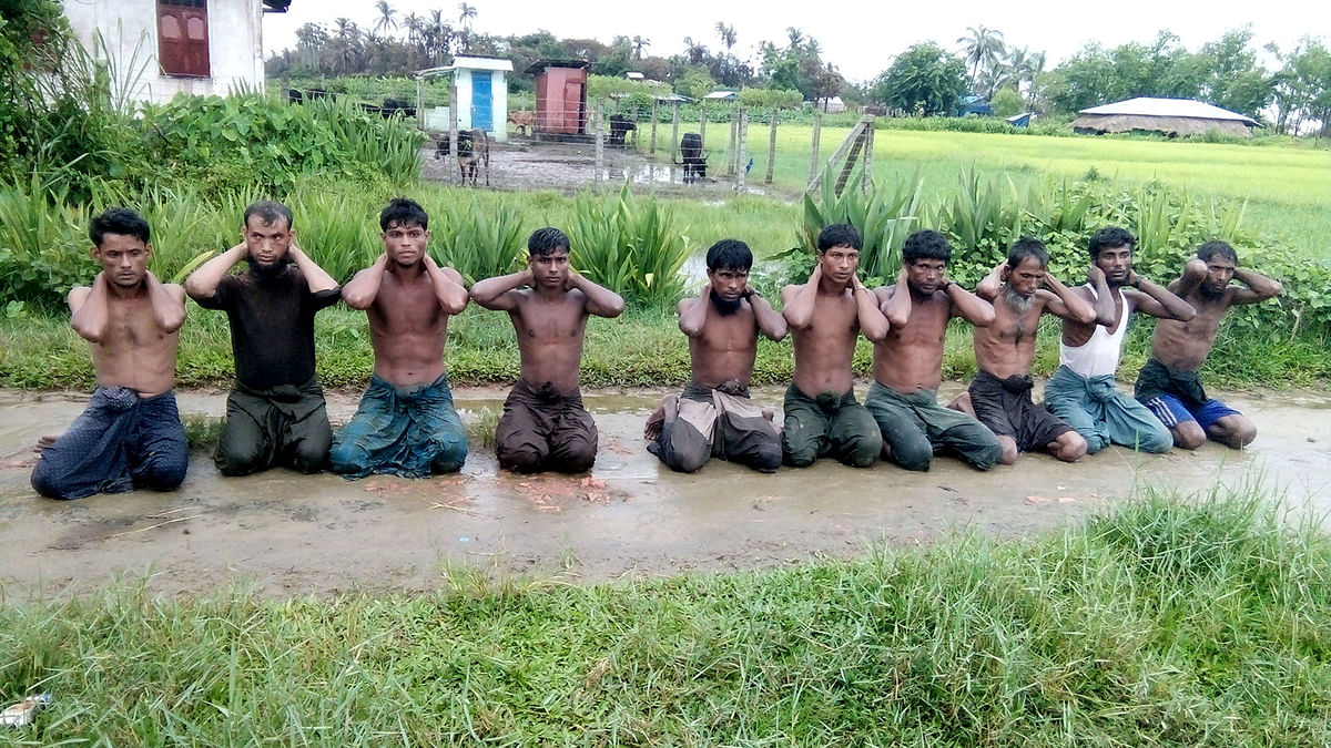 Ten Rohingya Muslim men with their hands bound kneel in Inn Din village, Myanmar, 1 September, 2017. Photo: Reuters