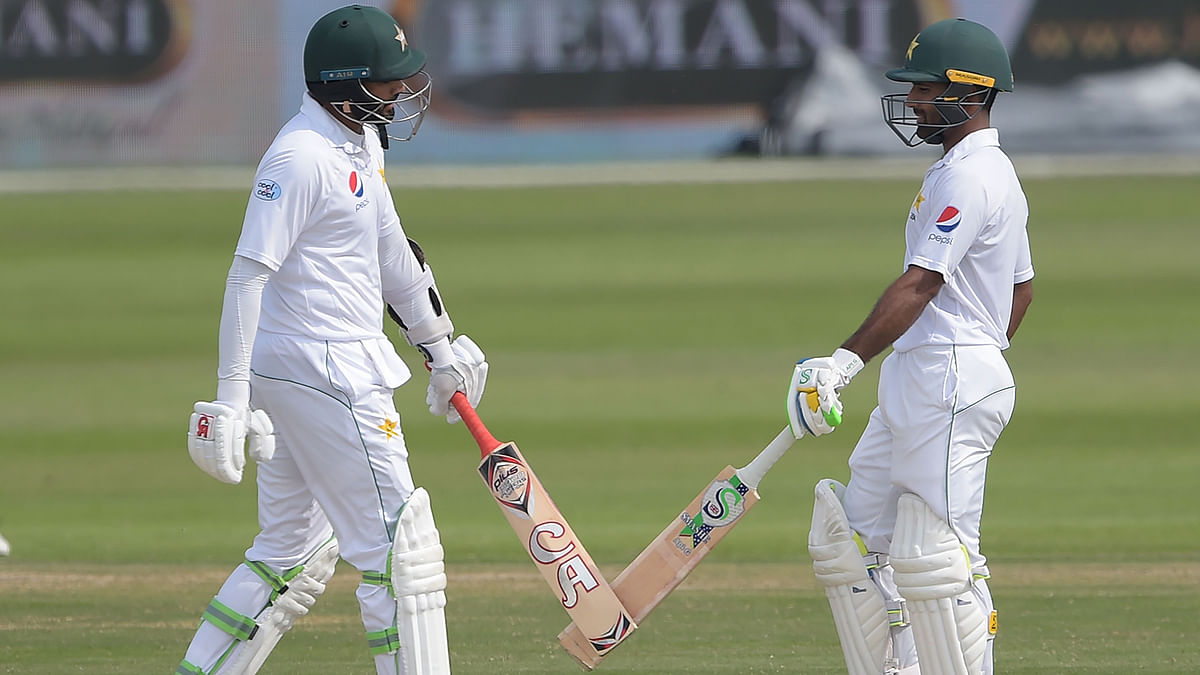 Pakistani batsmen Azhar Ali (L) and Asad Shafiq touch their bats during the third day of the third and final Test cricket match between Pakistan and New Zealand at the Sheikh Zayed International Cricket Stadium in Abu Dhabi on 5 December 2018. Photo: AFP