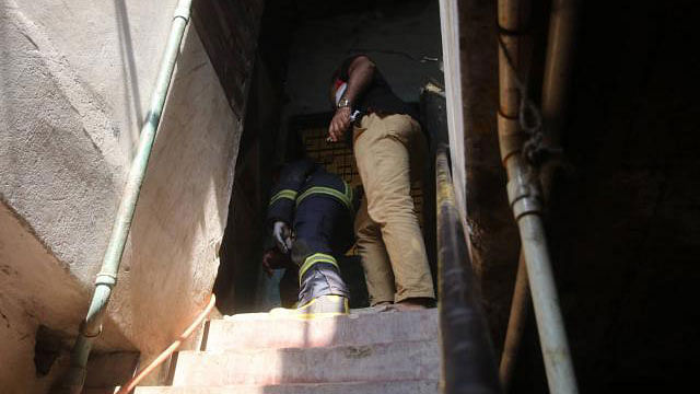 A fire fighter peeps through the door hole. Photo: Abdus Salam