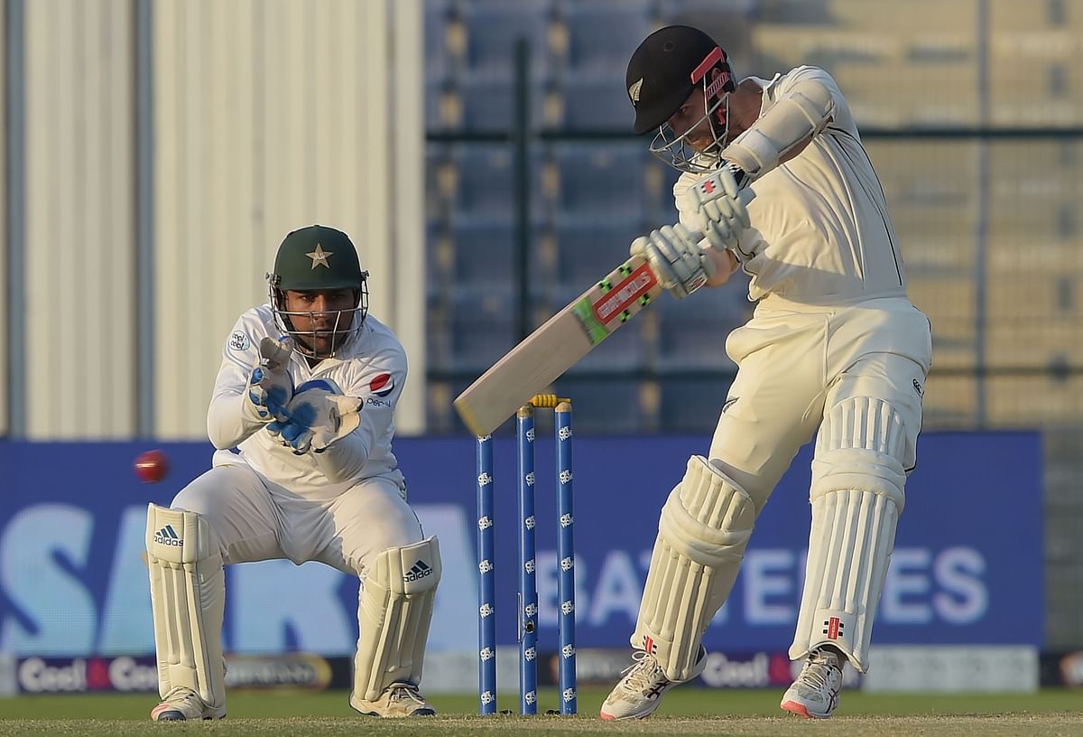 New Zealand captain Kane Williamson (R) plays a shot as Pakistani wicketkeeper captain Sarfraz Ahmed looks on during the third day of the third and final Test cricket match between Pakistan and New Zealand at the Sheikh Zayed International Cricket Stadium in Abu Dhabi on 5 December 2018. Photo: AFP