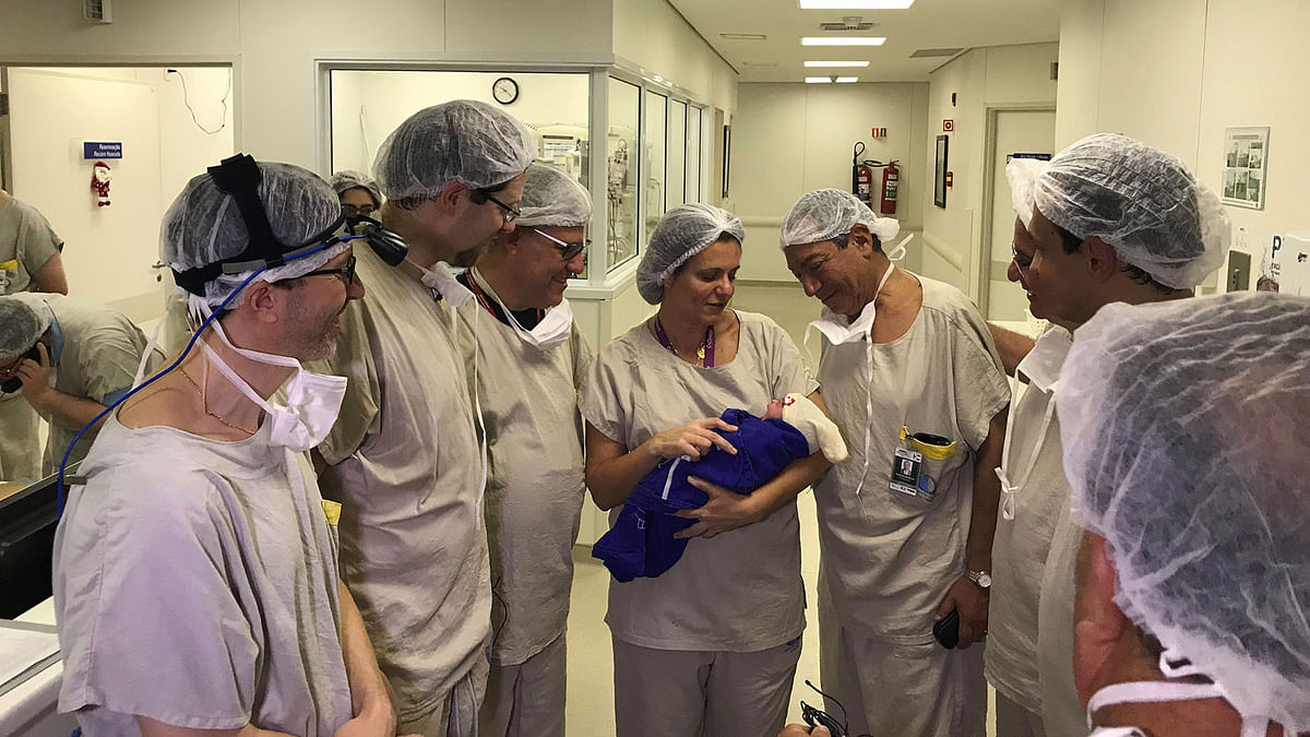 Medical team hold the first baby born via uterus transplant from a deceased donor, at the hospital in Sao Paulo. Photo: Reuters