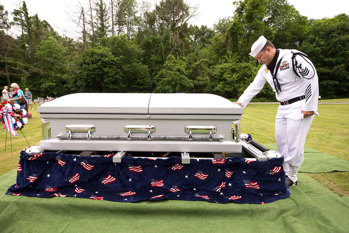 In this 9 June 2018, file photo, US Navy Master at Arms First Class Robert Linke, a Los Angeles native stationed at Naval Weapons Station Earle in Colts Neck, NJ, pauses at the casket of US Navy Seaman 1st Class Edward Slapikas, a Newport Township, Pa., native killed while serving aboard the USS Oklahoma in the attack on Pearl Harbor in Dec 1941, at St. Mary`s Cemetery in Nanticoke, Pa. Slapikas` remains were identified earlier this year and returned to Luzerne County for burial 77 years after his death. Photo: AP