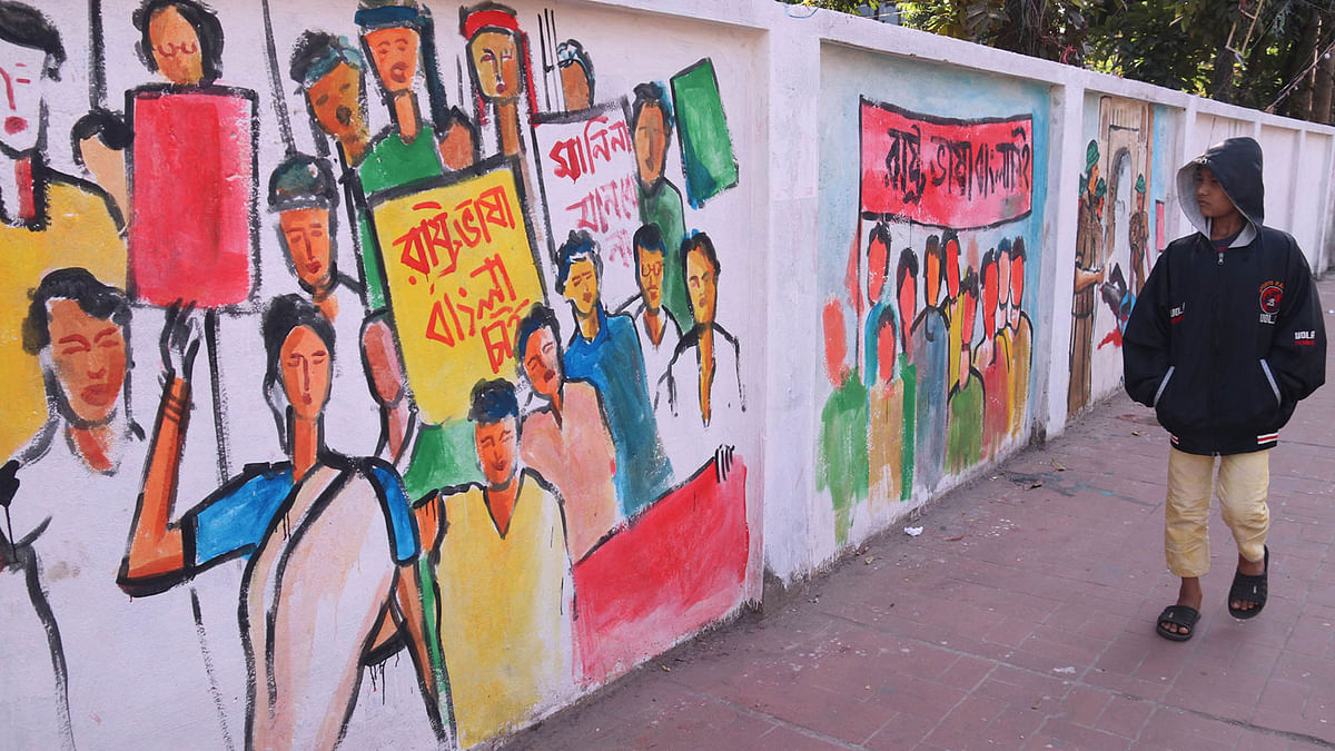 A boy walks past a mural titled ‘From the language movement till the liberation war’ on the wall of the Sylhet Government Girls’ College in Sylhet. 6 December. Photo: Anis Mahmud