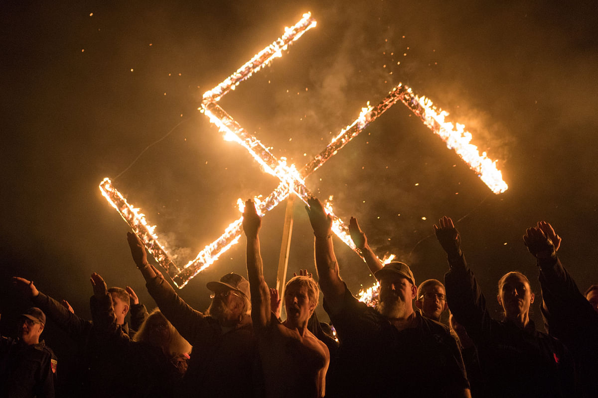 Supporters of the National Socialist Movement, a white nationalist political group, give Nazi salutes while taking part in a swastika burning at an undisclosed location in Georgia, US, 21 April  2018. Photo: Reuters