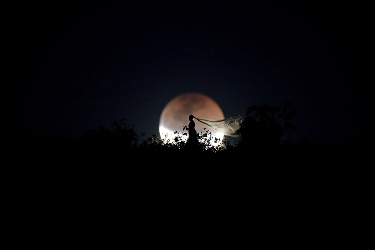 A bride poses for photo during a total lunar eclipse from in Brasilia, Brazil, 27 July, 2018. Photo: Reuters