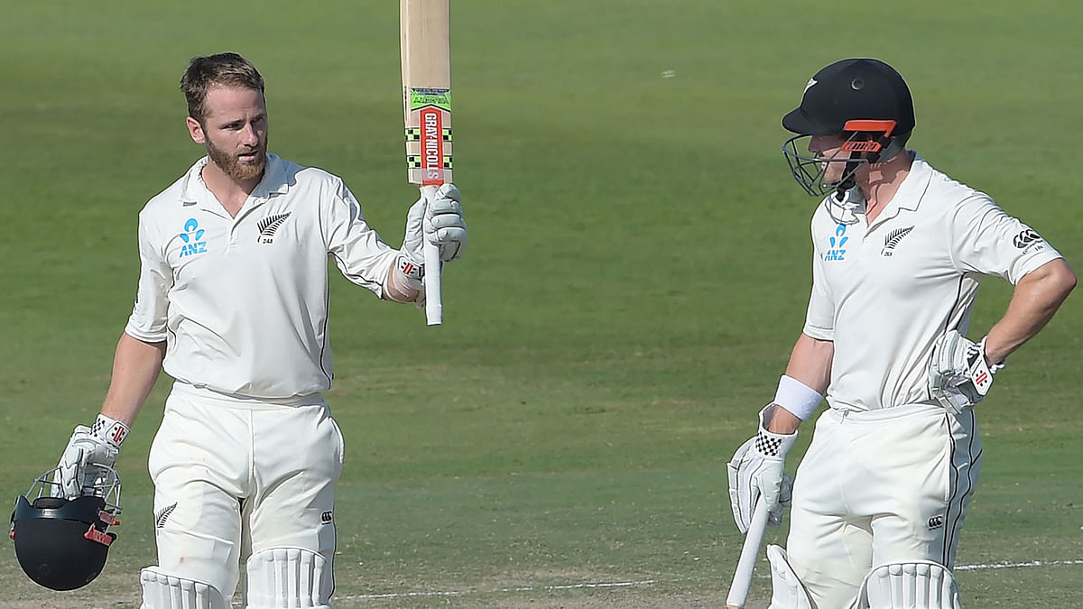 New Zealand captain Kane Williamson (L) celebrates after scoring a century (100 runs) as his teammate Henry Nicholls looks on during the fourth day of the third and final Test cricket match between Pakistan and New Zealand at the Sheikh Zayed International Cricket Stadium in Abu Dhabi on 6 December, 2018. Photo: AFP