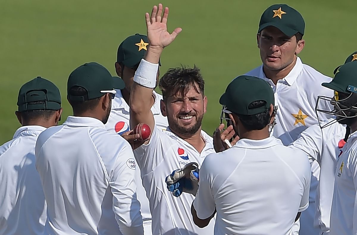 Pakistani spinner Yasir Shah (C) celebrates with teammates after breaking the fastest to 200 Test wickets record during the fourth day of the third and final Test cricket match between Pakistan and New Zealand at the Sheikh Zayed International Cricket Stadium in Abu Dhabi on 6 December 2018. Photo: AFP