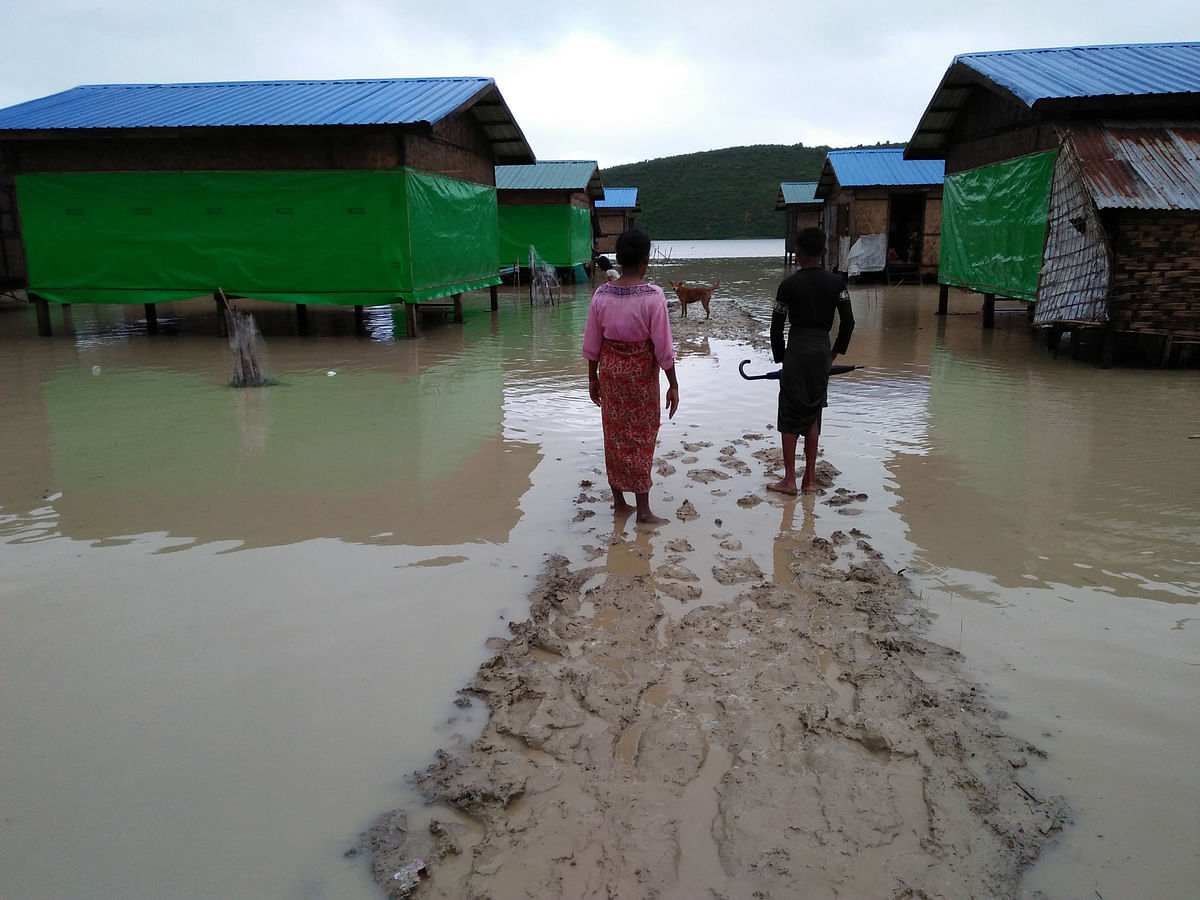Muslim residents at Taungpaw an internally displaced people`s camp walk through the flood to reach the new house built by the Myanmar government in central Rakhine. Photo: Reuters