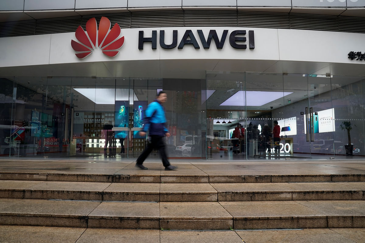 A man walks by a Huawei logo at a shopping mall in Shanghai. Photo: AFP