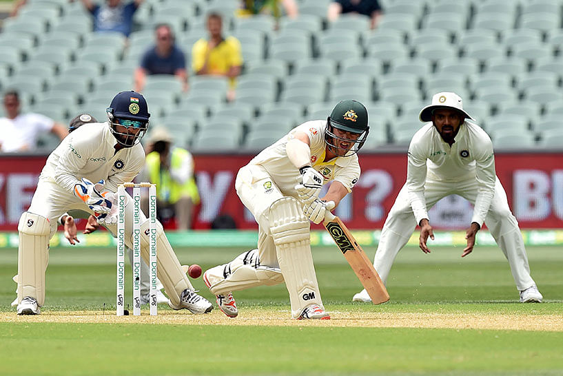 Australia`s batsman Travis Head (C) plays a shot as Indian wicketkeeper Rishabh Pant (L) looks on during day two of the first Test match at the Adelaide Oval on 7 December 2018. Photo: AFP
