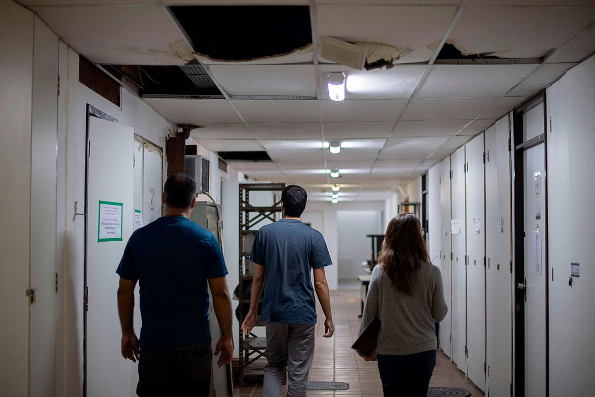 Students of the Federal University of Rio de Janeiro (UFRJ) walk along the hallway -with its damaged ceiling- of the UFRJ Health Sciences Centre building in Rio de Janeiro, Brazil, on 27 November 2018. Photo: AFP
