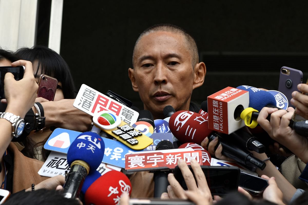 Film director Doze Niu (C), also known as Niu Chen-zer, is surrounded by the press outside a police station in Taipei on 7 December, 2018. Photo: AFP