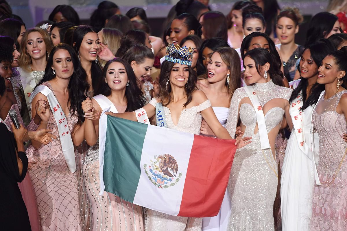 Miss Mexico Vanessa Ponce de Leon (C) dances with the Mexican flag as she celebrates with fellow contestants after she was crowned the winner of the 68th Miss World final in Sanya, on the tropical Chinese island of Hainan on 8 December, 2018. Photo: AFP