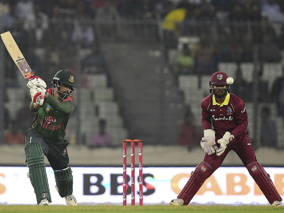 Bangladesh cricketer Tamim Iqbal (L) plays a shot as the West Indies cricketer Shai Hope (R) looks on during the first One Day International (ODI) between Bangladesh and West Indies at the Sher-e-Bangla National Cricket Stadium in Dhaka on December 9, 2018. AFP