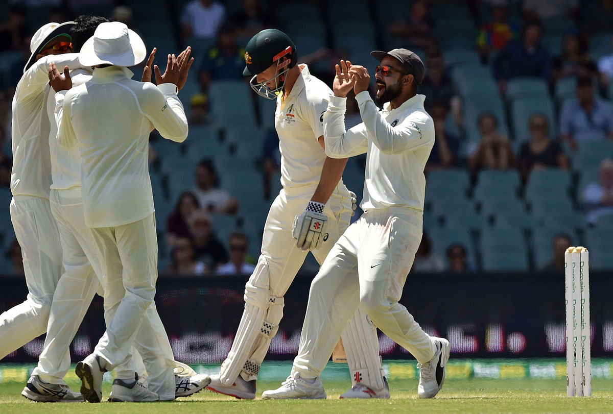 India`s captain Virat Kohli (R) celebrates the dismissal of Australia`s batsman Shaun Marsh (2nd R) with teammates during day five of the first Test cricket match between Australia and India at the Adelaide Oval on 10 December, 2018. Photo: AFP