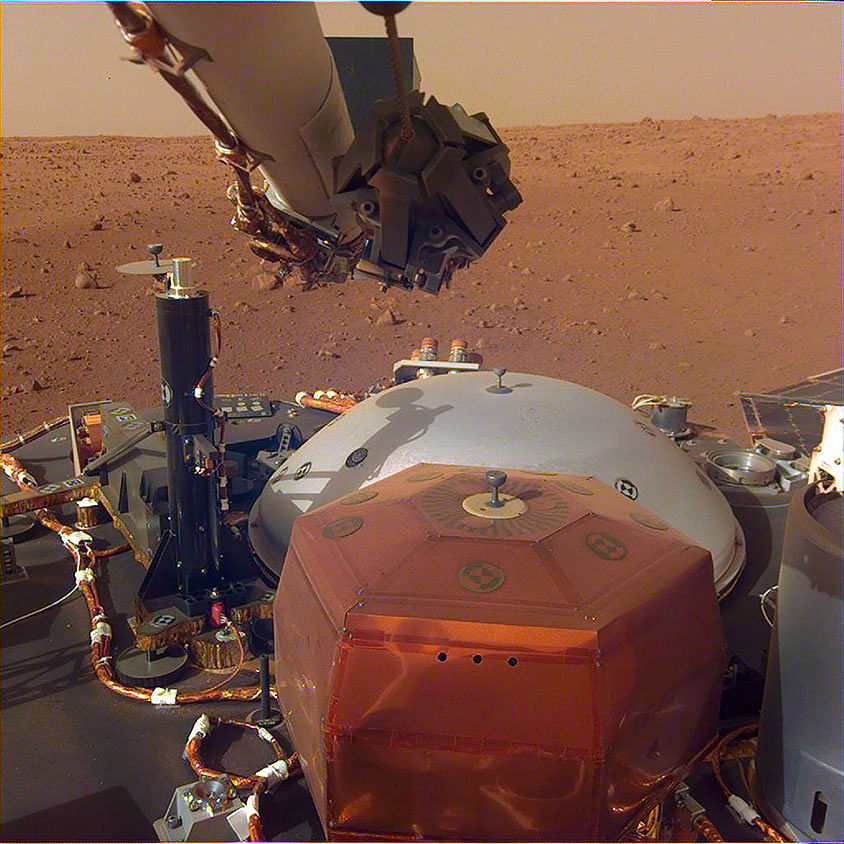 In this image obtained from NASA, InSight`s robotic-arm mounted Instrument Deployment Camera shows the instruments on the spacecraft`s deck, with the Martian surface of Elysium Planitia in the background. The color-calibrated picture was acquired on 4 December 2018. Photo: AFP