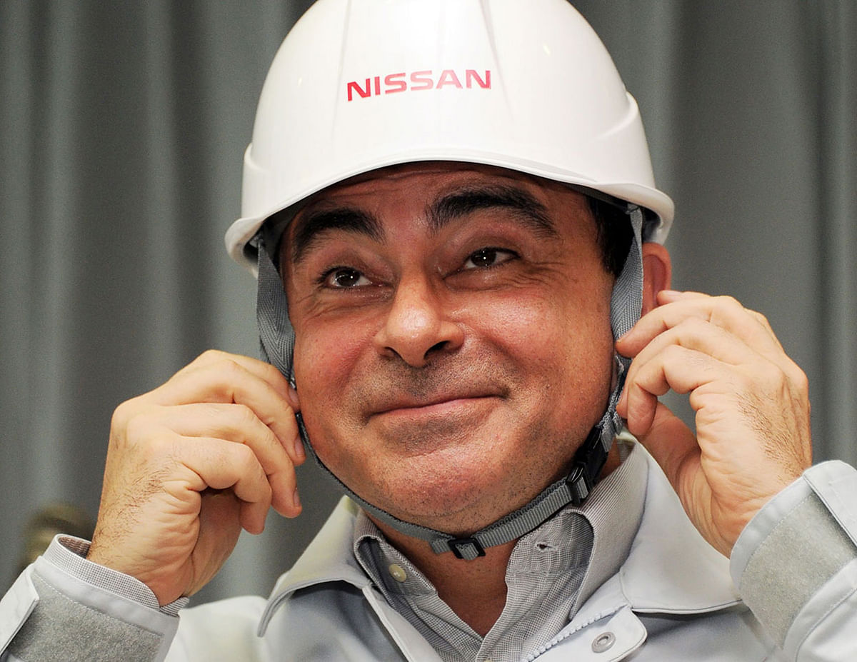 In this file photo taken on 17 May 2011, Nissan president and CEO Carlos Ghosn smiles as he puts on a helmet presented by factory workers while attending a ceremony to resume work on the assembly line at the company`s Iwaki engine plant in Iwaki, Fukushima prefecture. Photo: AFP