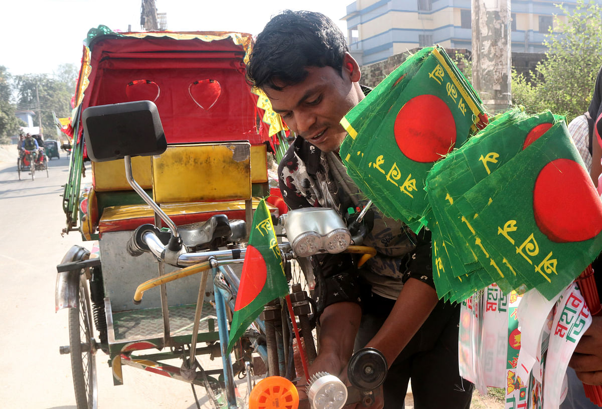 A rickshaw puller setting up a flag of Bangladesh on his rickshaw at Seujgari, Bogura on 10 December. Photo: Soel Rana