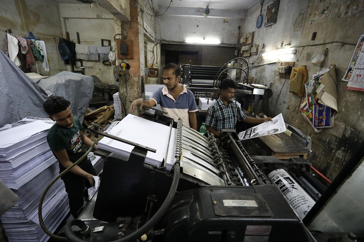 Workers in a press busy with printing posters ahead of the 11th parliamentary elections at Babu Bazar in Dhaka on 10 December. Photo: Dipu Malakar