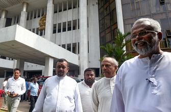 Sri Lankan member of parliament Douglas Devananda (R) and Dinesh Gunawardena (2R) look on outside the Supreme Court in Colombo on 12 December 2018. Sri Lanka`s ousted prime minister promised on 10 December, to bring tens of thousands of supporters to the capital next week for a massive demonstration unless president Maithripala Sirisena reinstated him imminently. Photo: AFP