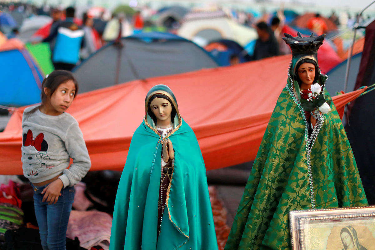 A child stand next to an image of the Virgin of Guadalupe at the Basilica of Guadalupe during the annual pilgrimage in honor of the Virgin of Guadalupe, patron saint of Mexican Catholics, Mexico City, Mexico 11 December 2018. Photo: Reuters