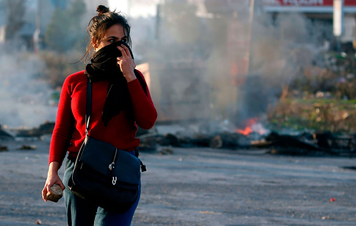 A Palestinian demonstrator covers her face during clashes with Israeli troops in Ramallah, near the Jewish settlement of Beit El, in the occupied West Bank on 13 December, 2018. Photo: AFP