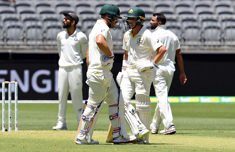Australia`s batsmen Marcus Harris (R) and Aaron Finch wait for a third umpire decision during day one of the second Test cricket match between Australia and India in Perth on 14 December 2018. Photo: AFP