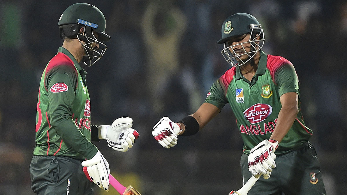 Bangladesh cricketer Tamim Iqbal (L) celebrates with his teammate Soumya Sarkar (R) after hitting a boundary during the third one-day international (ODI) between Bangladesh and West Indies at the Sylhet International Cricket Stadium in Sylhet on December 14, 2018. AFP
