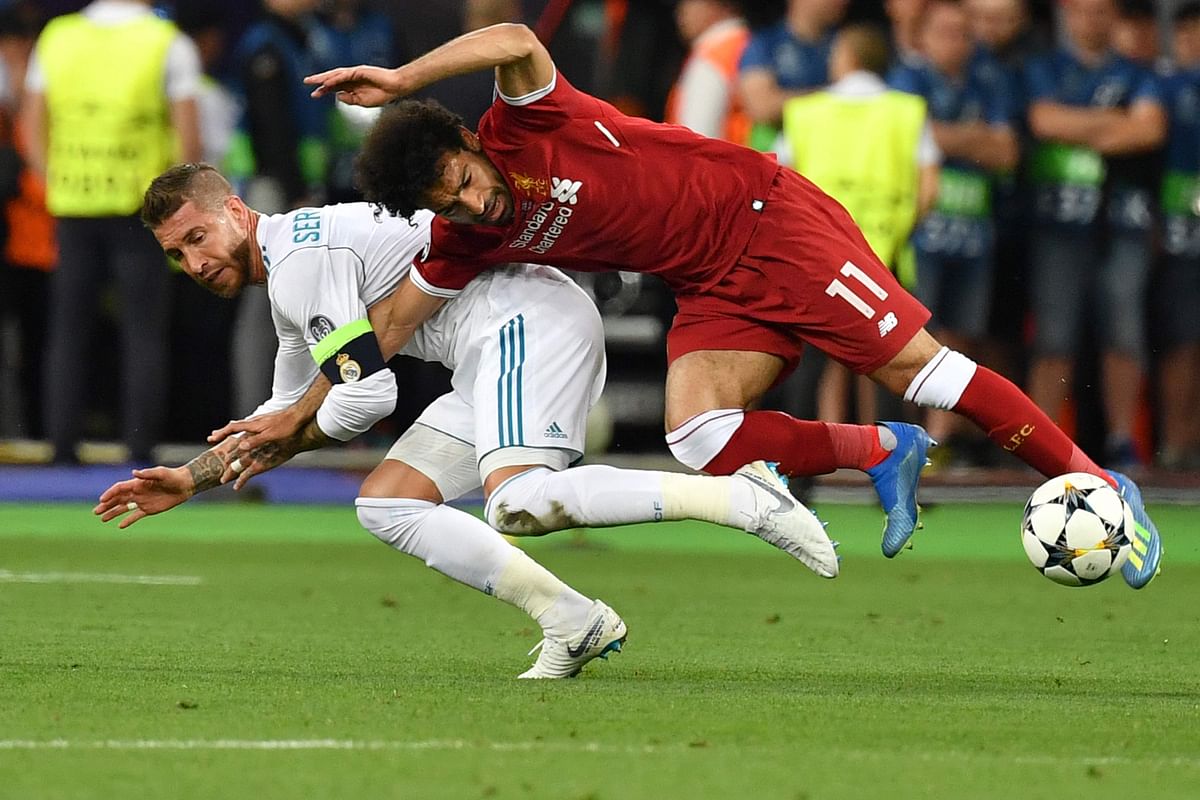 In this file photo taken on 26 May 2018 Liverpool`s Egyptian forward Mohamed Salah (R) falls with Real Madrid`s Spanish defender Sergio Ramos leading to Salah being injured during the UEFA Champions League final football match between Liverpool and Real Madrid at the Olympic Stadium in Kiev, Ukraine. Photo: AFP