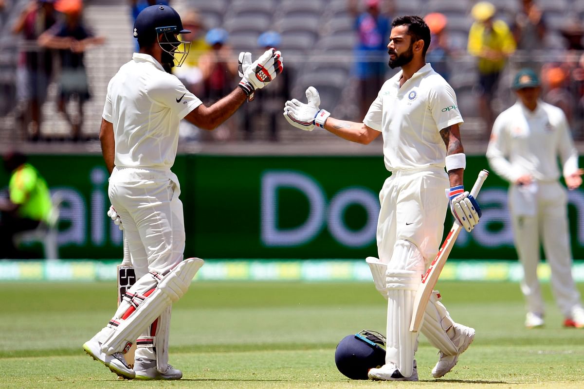 India`s batsman Virat Kohli (R) celebrates with teammate Hanuma Vihari after scoring his century against Australia on the third day of the second cricket Test match in Perth on 16 December 2018. Photo: AFP