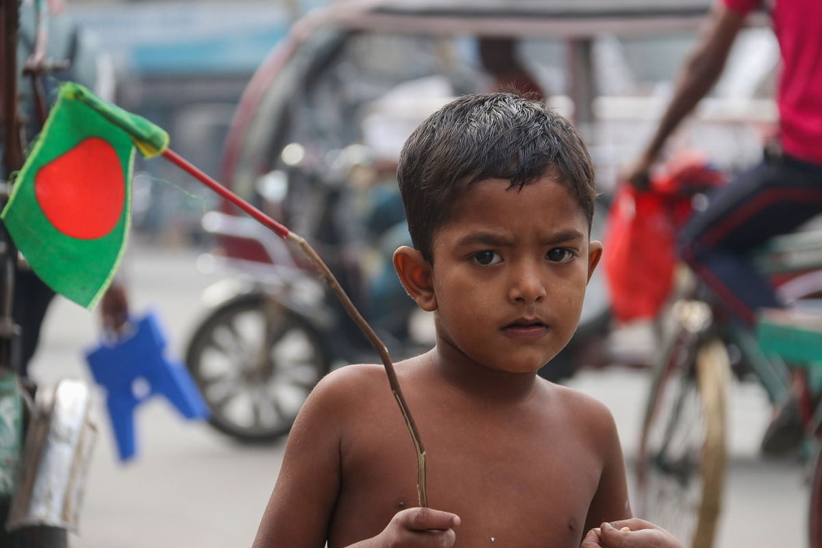 A child holding a flag of Bangladesh at Moylapota intersection in Khulna on 15 December. Photo: Saddam Hossain