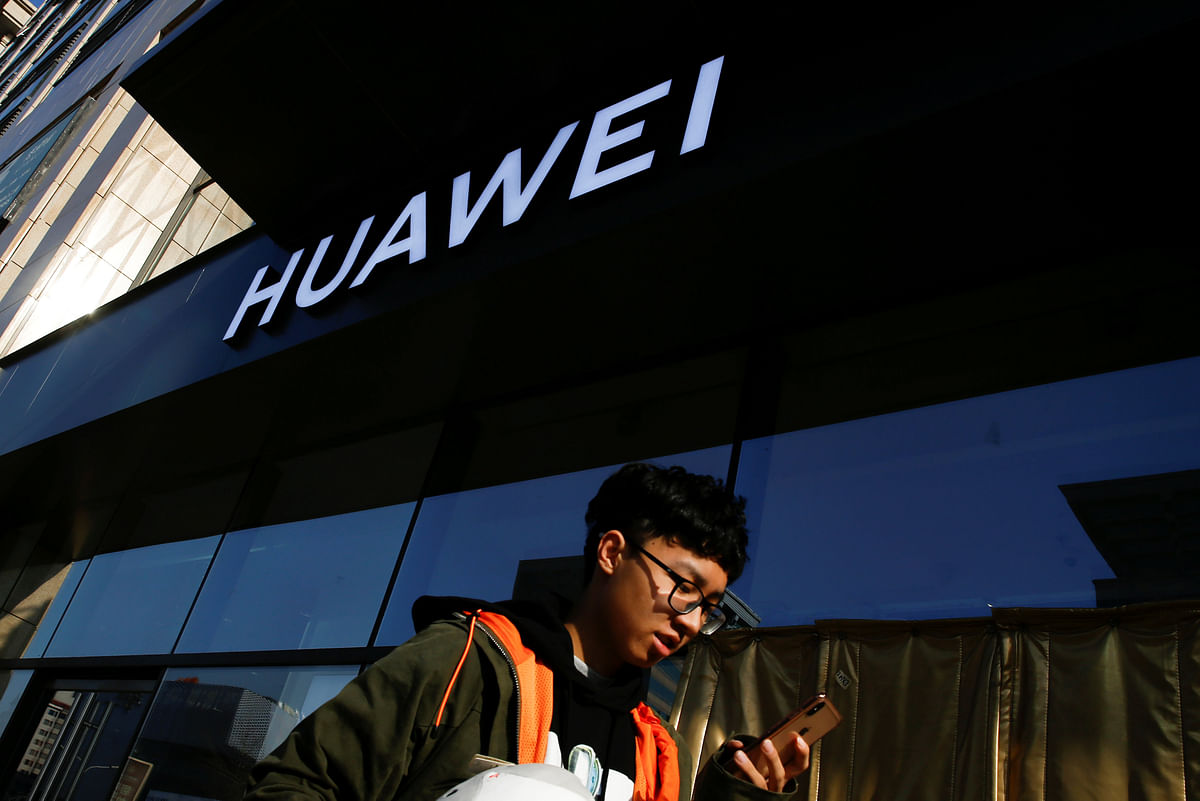 A man uses his phone as he walks past a Huawei shop in Beijing, China, on 19 December 2018. Photo: Reuters