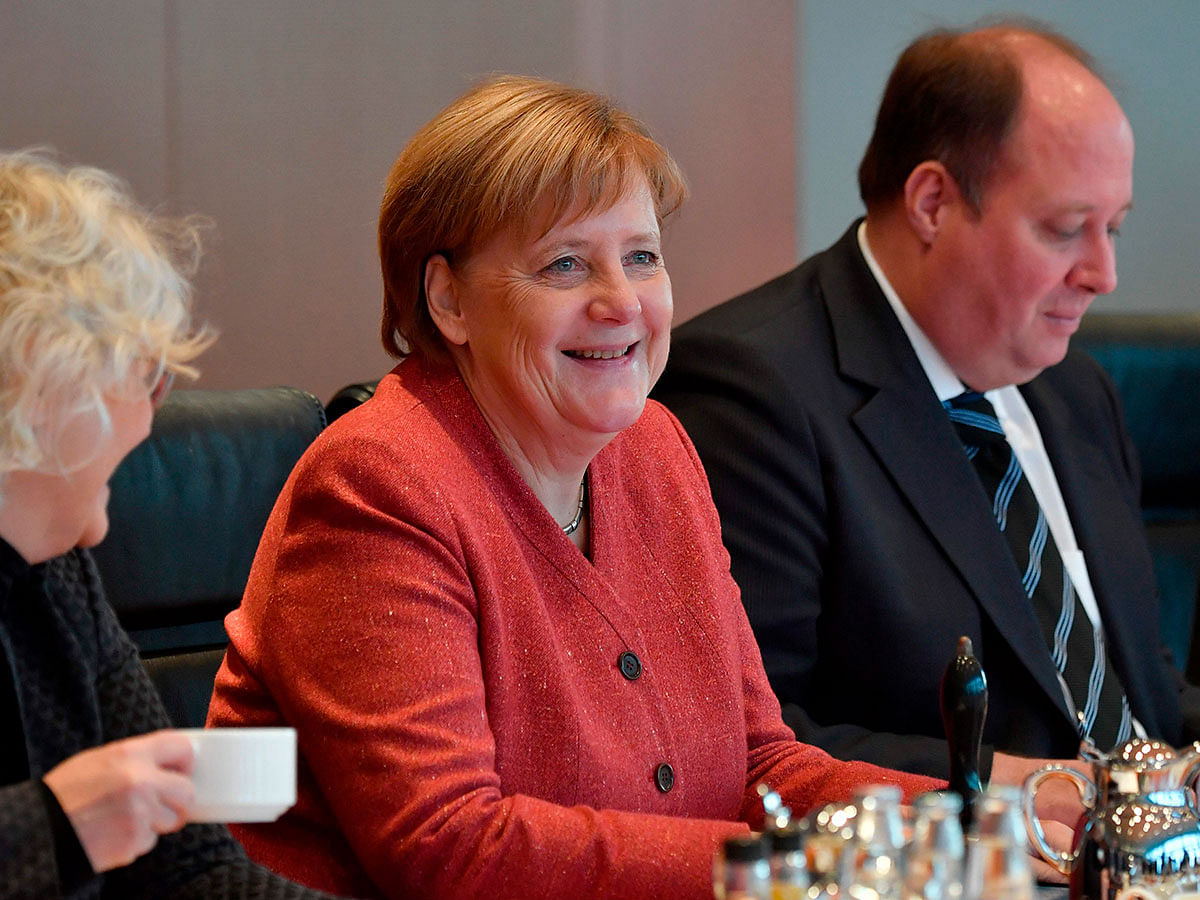 German Chancellor Angela Merkel (C) smiles as she prepares to lead the weekly cabinet meeting on 19 December 2018 at the Chancellery in Berlin. Photo: AFP