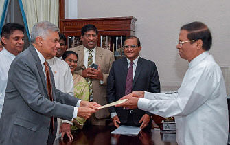 This handout released by Sri Lanka president media on 16 December 2018, shows Sri Lankan president Maithripala Sirisena (R) handing over documents to Ranil Wickremesinghe (L) as he is reappointed as prime minister in Colombo. Sri Lanka`s president on 16 December reappointed as prime minister the same man he sacked from the job nearly two months ago, ending a messy power struggle that had paralysed the island nation. Photo: AFP
