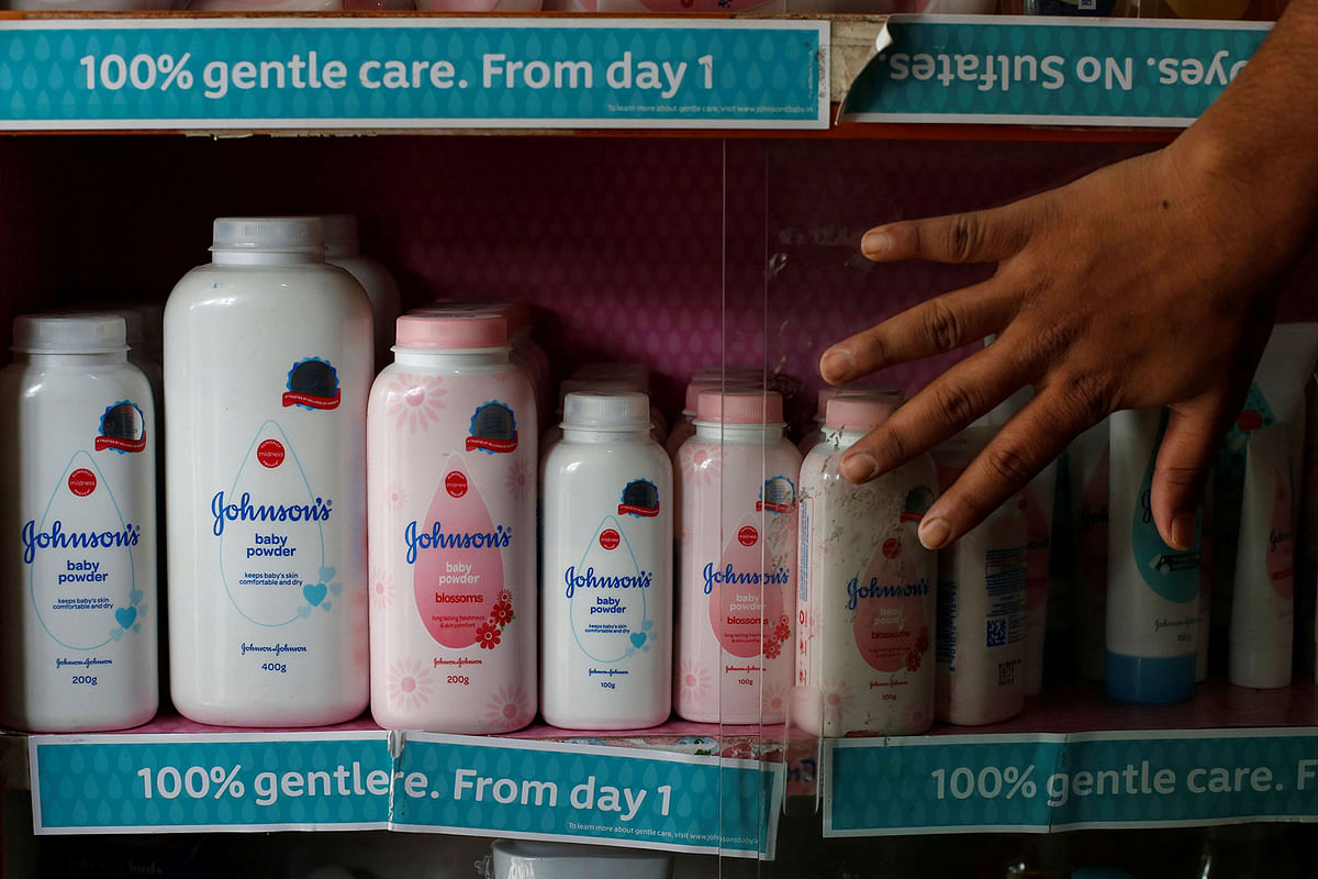 A worker closes a glass cabinet of Johnson & Johnson baby powder bottles at a medical store in Kolkata, India, 20 December 2018. Reuters File Photo