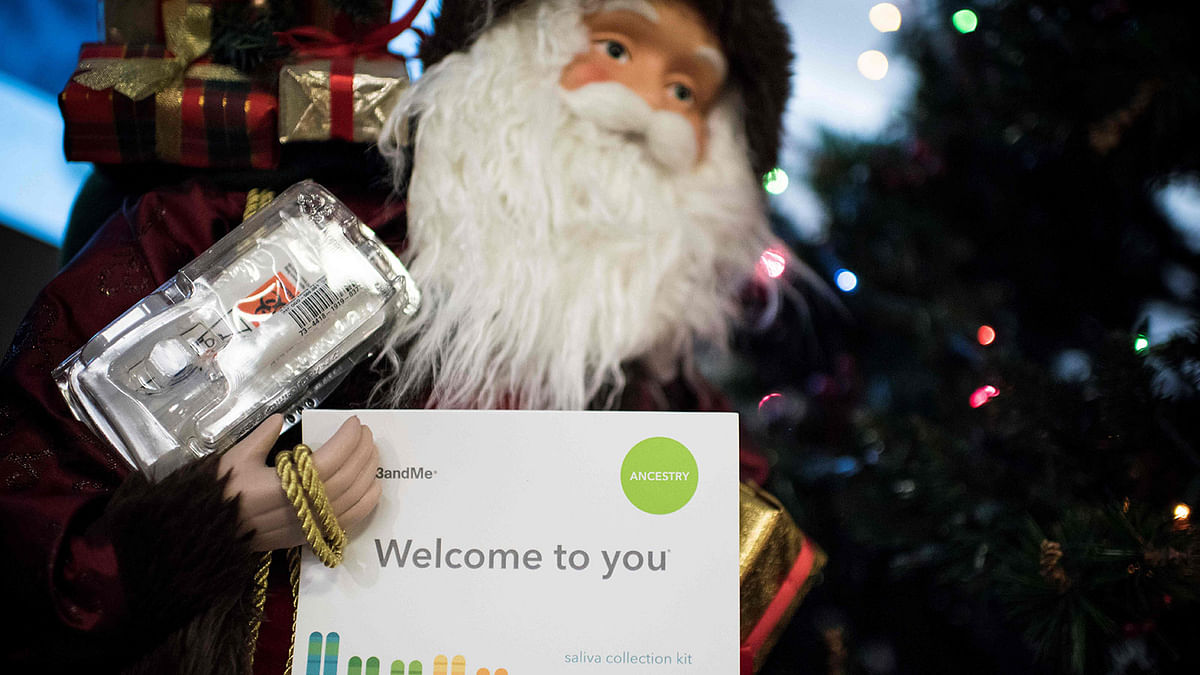 This illustration picture shows a saliva collection kit for DNA testing displayed in the arms of a Father Christmas doll in Washington, DC on 19 December 2018 as Americans are increasingly offering those tests to relatives during the Holiday season. Photo: AFP