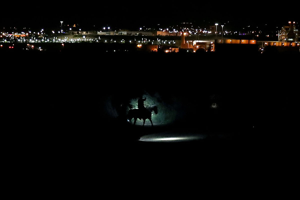 Border Patrol agents on horses track a man along the Rio Grande River after he illegally crossed into the US from Mexico in Sunland Park, New Mexico, US, 15 June 2018. Photo: Reuters