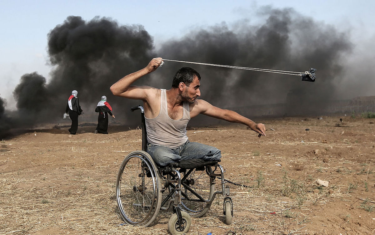 Palestinian Saber al-Ashkar, 29, hurls rocks during clashes with Israeli forces along the border with the Gaza strip, east of Gaza City, on 11 May 2018, as Palestinians demonstrate for the right to return to their historic homeland in what is now Israel. Photo: AFP