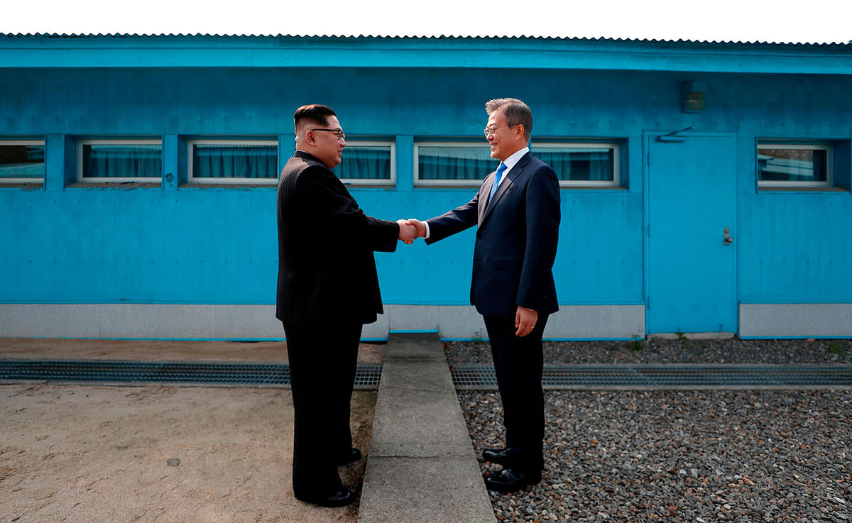 North Korea`s leader Kim Jong Un (L) shakes hands with South Korea`s President Moon Jae-in (R) at the Military Demarcation Line that divides their countries ahead of their summit at the truce village of Panmunjom on 27 April 27, 2018. North Korean leader Kim Jong Un and the South`s President Moon Jae-in sat down to a historic summit on 27 April after shaking hands over the Military Demarcation Line that divides their countries in a gesture laden with symbolism. Photo: AFP