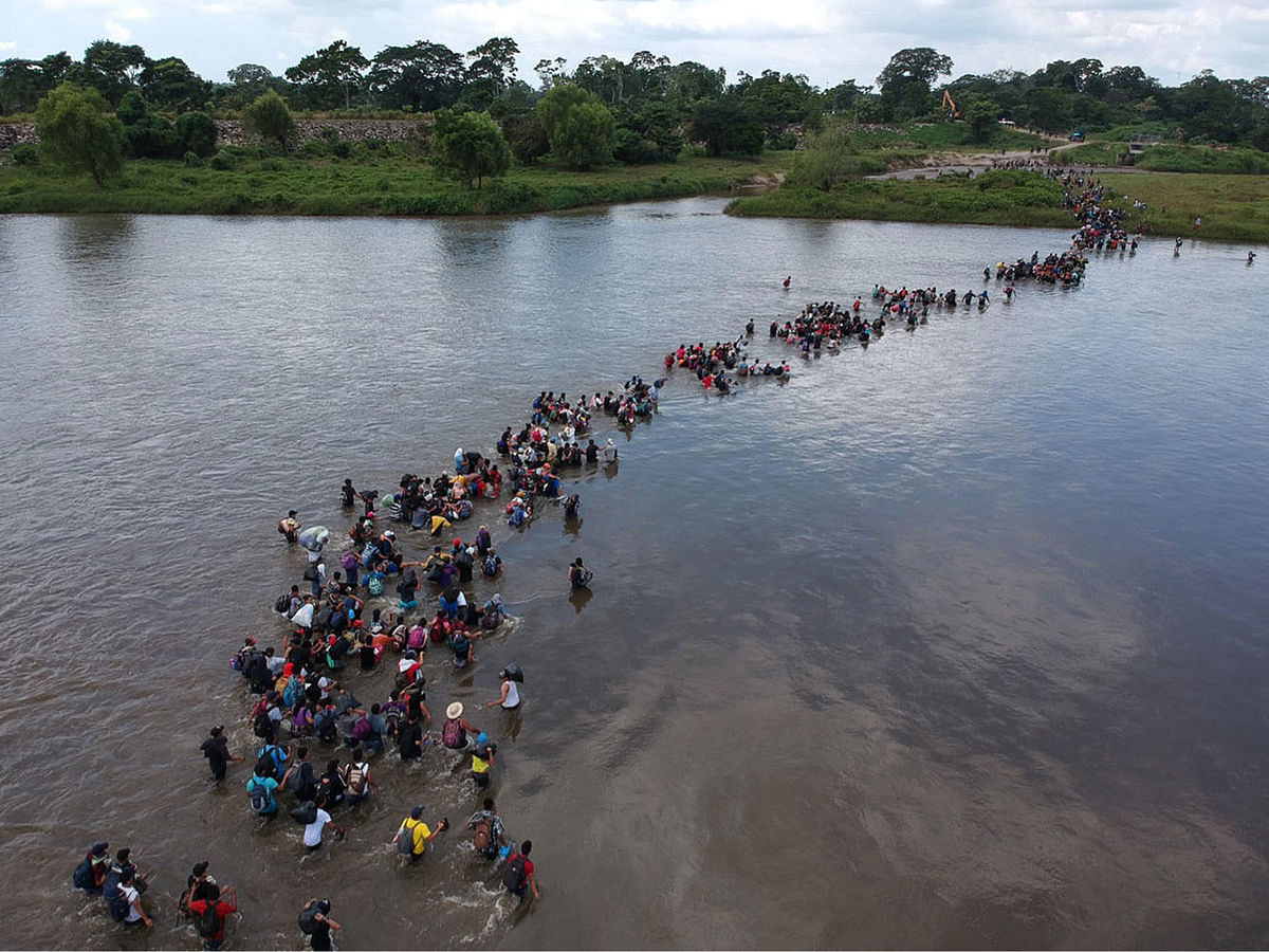Aerial view of Salvadorean migrants heading in a caravan to the US, crossing the Suchiate River to Mexico, from Ciudad Tecun Uman, Guatemala, on 2 November, 2018. According to the Salvadorean General Migration Directorate (DGME), over 1,700 Salvadoreans left the country in two caravans and entered Guatemala Wednesday, in an attempt to reach the US. Photo: AFP