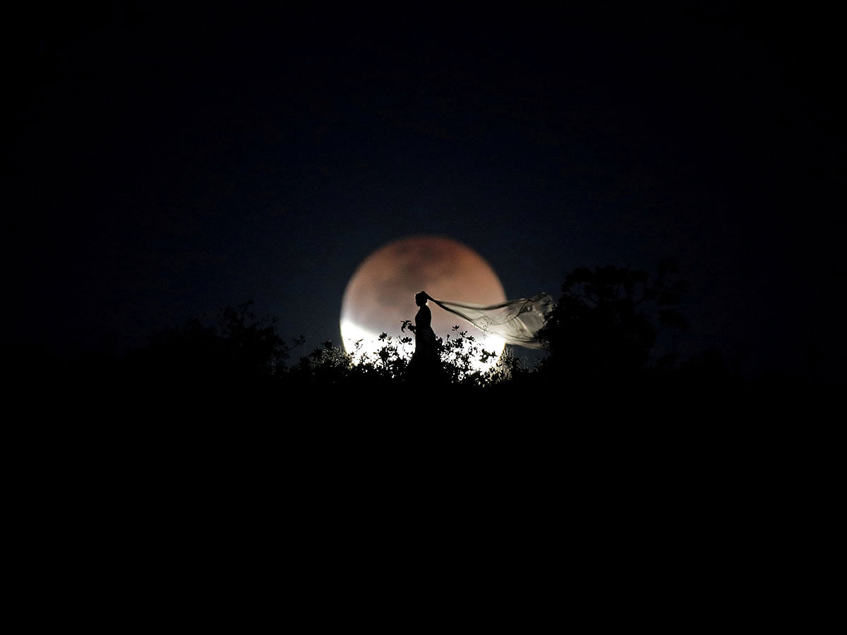 A bride poses for photo during a total lunar eclipse from in Brasilia, Brazil, 27 July 2018. Photo: Reuters